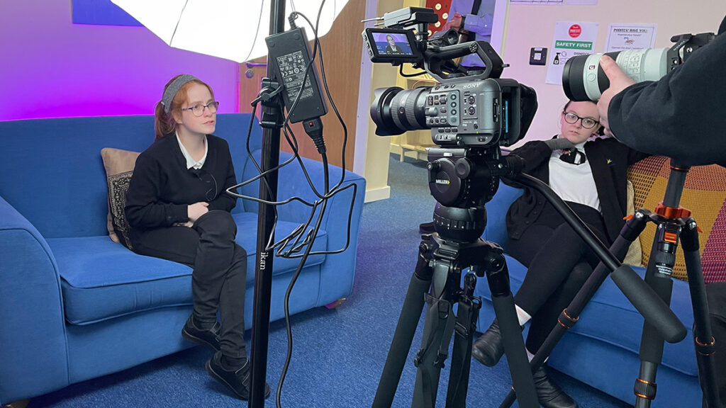 A student from Exhall Grange school is being filmed while another student watches